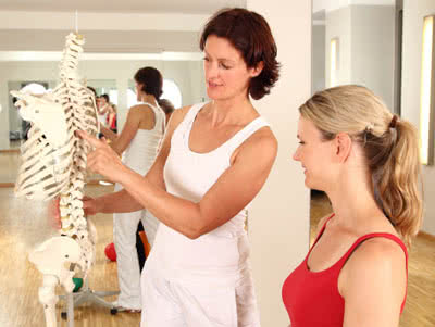 Betriebliche Krankenversicherung - Physiotherpeutin erlärt Patientin Wirbelsäule