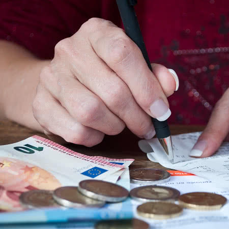Firmenrechtsschutzversicherung Kosten - Geldscheine mit Taschenrechner