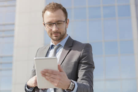 Gebäudeversicherung Kosten - Mann recherchiert mit einem Tablet