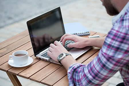 Motorrad Versicherung - Mann recherchiert am Laptop