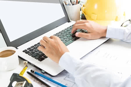 Betriebshaftpflicht Bauzeichner - Bauzeichner recherchiert am Laptop