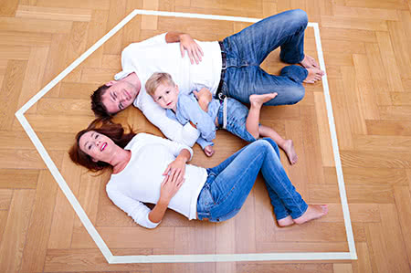 versicherungscheck24.de – Bauleistungsversicherung – Vergleich – Familie liegt glücklich auf dem Boden