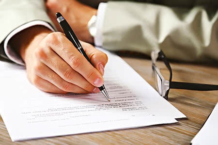 versicherungscheck24.de – Feuerrohbauversicherung Dauer – Mann macht sich Notizen auf Dokumenten