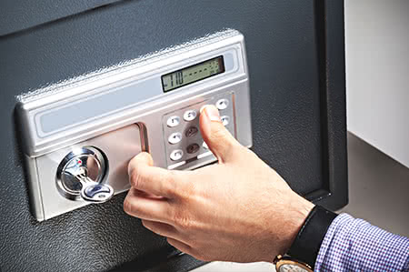 versicherungscheck24.de – Hausratversicherung – Tresor – Mann gibt Code in Tresor ein