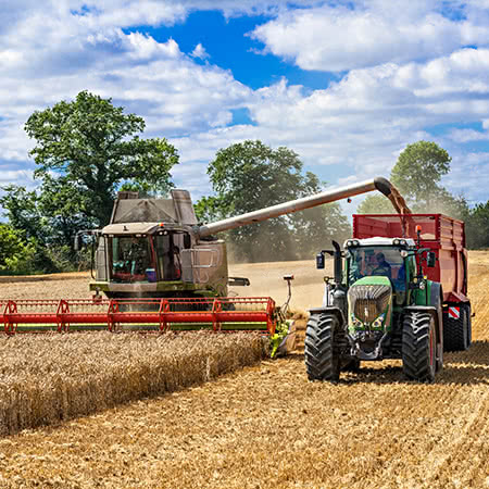 versicherungscheck24.de – Maschinenversicherung Mähdrescher – Landwirtschaftsmaschine ackert Feld