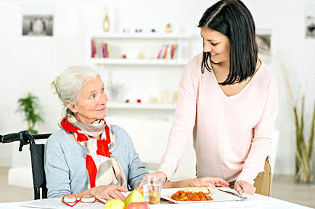 versicherungscheck24.de – Pflegeversicherung – Definition – Seniorin wird Essen gebracht