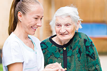 versicherungscheck24.de – Pflegeversicherung – Leistungen – Seniorin mit Pflegerin