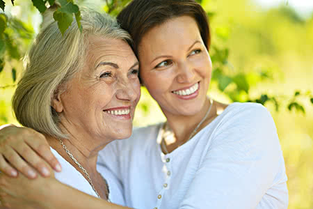 versicherungscheck24.de – Pflegeversicherung für Eltern – Mutter mit Tochter schaut freundlich in der Natur