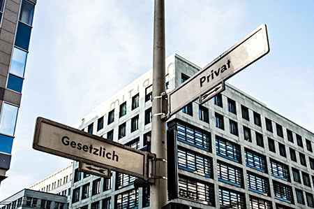 versicherungscheck24.de – Pflegeversicherung – Pflicht – Wegweiser mit der Aufschrift gesetztlich und privat