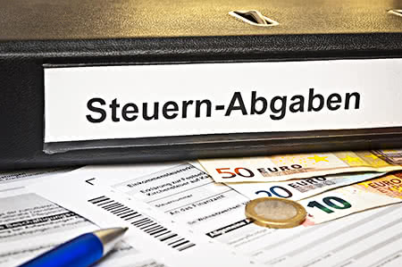 versicherungscheck24.de – Pflegeversicherung steuerlich absetzbar – Akten mit der Beschriftung Steuern und Bargeld