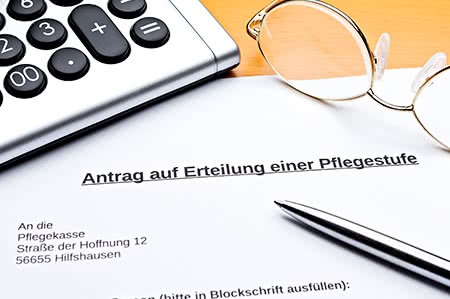 versicherungscheck24.de – Pflegeversicherung – Stufe 1 – Senior hält seine kleine Enkelin auf dem Arm