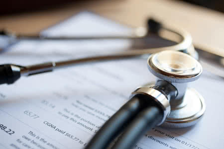 Berufshaftpflicht Kardiologe - Unterlagen mit einem Sthetoskop drauf