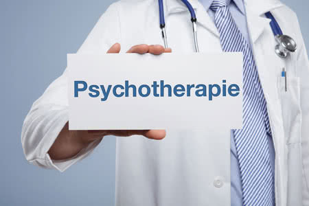 Berufshaftpflicht Psychotherapeut - Arzt mit einem Psychotherapie Schild in der Hand