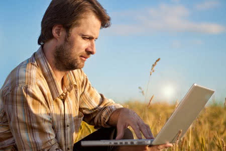 Landwirtschaftliche Betriebshaftpflichtversicherung - Landwirt mit einem Laptop