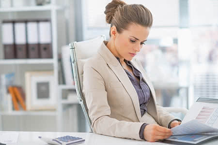 Cyber Risk Versicherung - Frau mit einem Taschenrechner