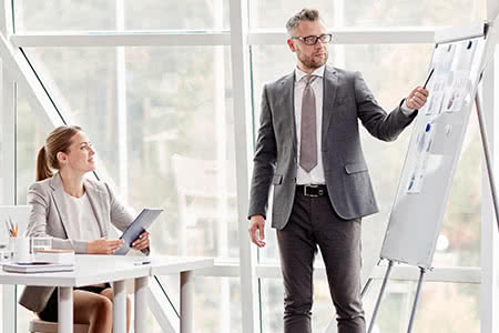 Gewerbehaftpflichtversicherung - Mann erklärt an einer Flipchart die Kosten