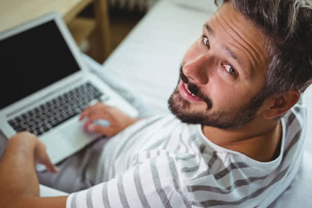 Hab und Gut versichern – Die Deutschen tun es mit einer Elektronikversicherung - Mann mit einem Laptop