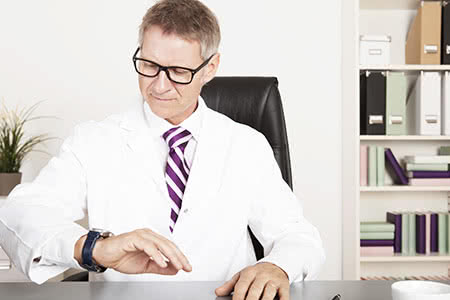 Laborversicherung - Mann schaut auf eine Uhr