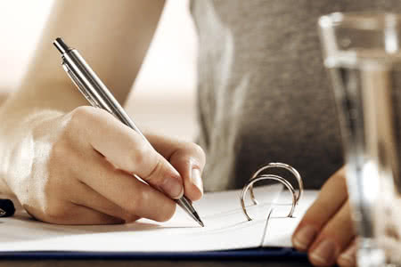 Praxisversicherung Angebot - Frau unterschreibt Unterlagen