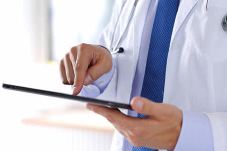 Praxisversicherung Kosten - Arzt vergleicht am Tablet