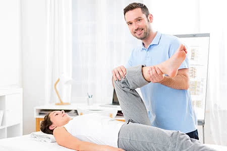 Private Krankenversicherung für Physiotherapeuten - Junger Physiotherapeut beim arbeiten