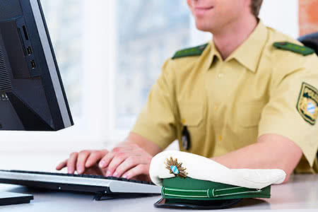 Private Krankenversicherung für Polizeibeamte / Polizisten - Polizist am Laptop