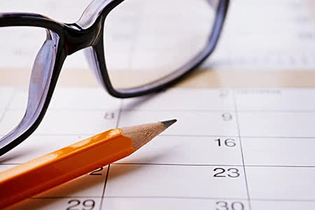 Wechsel in der privaten Krankenversicherung - Kalender mit einer Brille und einem Stift