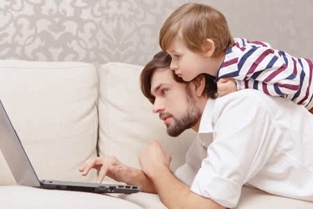 Private Krankenversicherung für Kleinkinder - Papa mit Sohn recherchiert am Laptop