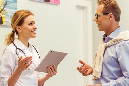 Private Krankenversicherung für Kassenpatienten - Ärztin mit einem Patienten in Bertatung