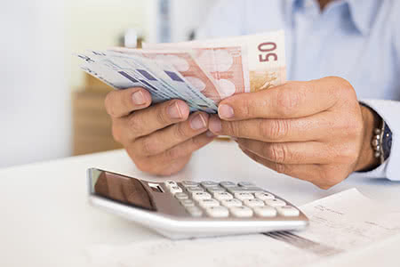 Softwareversicherung - Geldscheine mit einem Taschenrechner