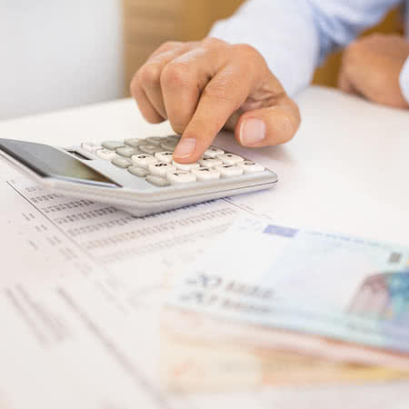 Wann zahlt Gebäudeversicherung? - Mann rechnet mit einem Taschenrechner