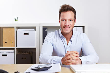 Bürgschaftsversicherung - Zufriedener Geschäftsmann im Büro